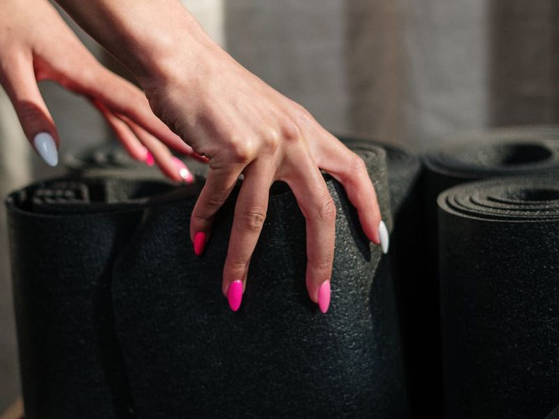 Detail shot of a hand resting on a yoga mat during a break.